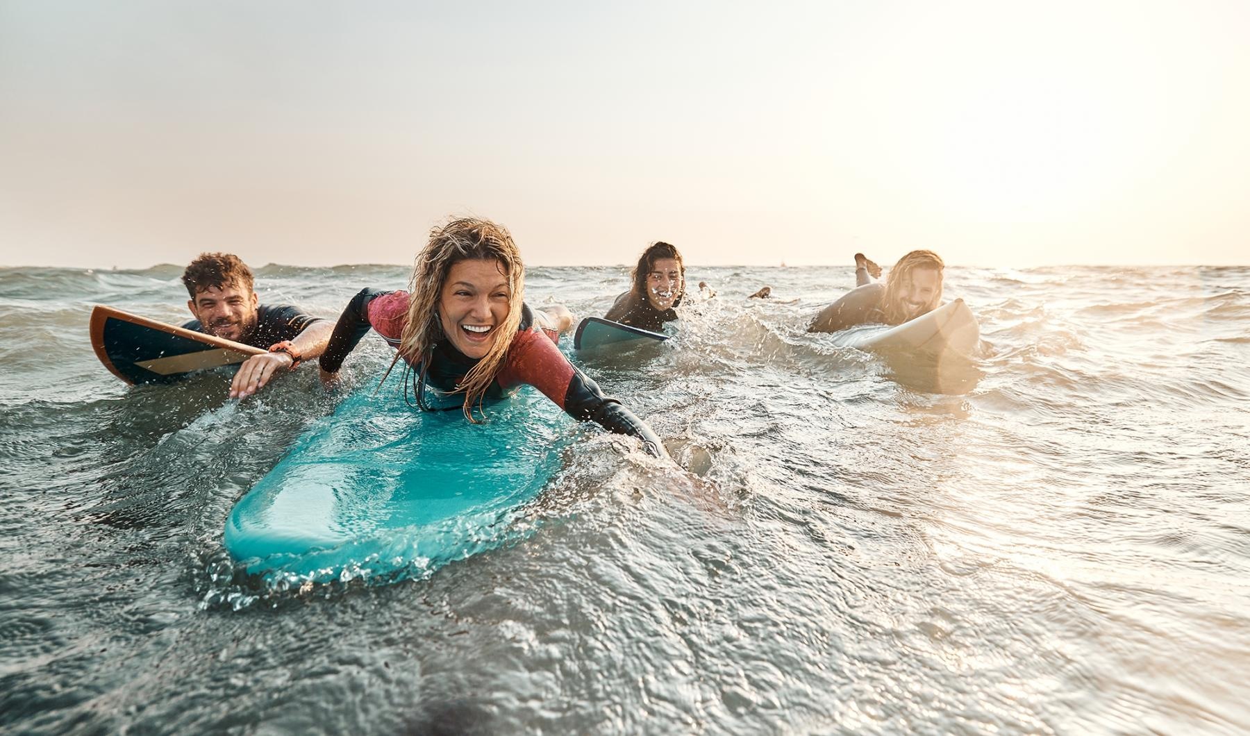 a group of people surfing in the sea